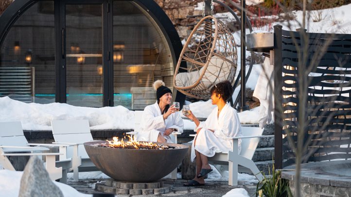 Two people sitting next to the fire at Oceanstone Resort and Spa.